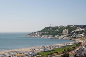 a view of a beach with buildings and the ocean at le Sunset Loft 88 maison neuve et moderne in Sainte-Adresse