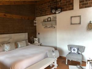 a bedroom with a large bed and a chair at Iztak - Xamikal in Zacatl&aacute;n