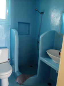 a blue bathroom with a toilet and a sink at Ammos Studio in Koufonisia