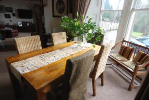 a dining room table with chairs and a vase of flowers at Gramarcy House in Brechin