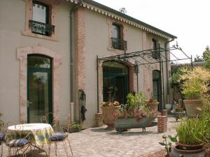 a house with a patio with a table and chairs at Au Fond de la Cour in Veyre-Monton