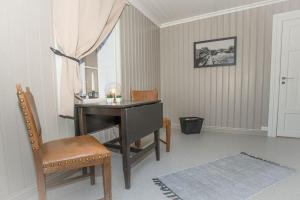 Zimmer mit einem Schreibtisch, einem Stuhl und einem Klavier in der Unterkunft Vrangfoss Sluse in Nes