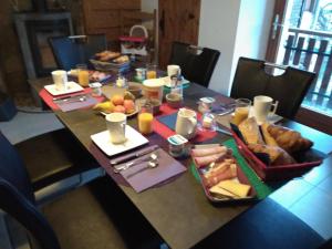 a table with a tray of bread and fruit on it at juste pour le plaisir in Saint-Pierre-dʼAlbigny