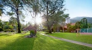 a park with a bench in the grass at The Bayview Beach Resort in Batu Ferringhi