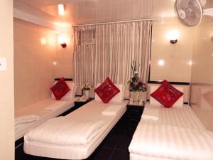 Pokój z 2 białymi łóżkami i czerwonymi poduszkami w obiekcie Melbourne Hostel Block E 10th floor w Hongkongu