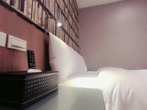 台北的住宿－耘荷居 Yún Inn，卧室配有白色的床和遥控器