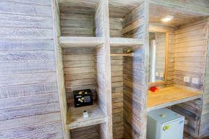 een badkamer met een toilet in een houten muur bij Lotus Garden Huts in Nusa Lembongan