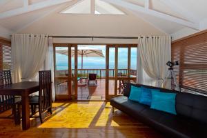 - un salon avec un canapé noir et une table dans l'établissement Aquamarine Guest House, à Mossel Bay