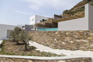 a rendering of a house with a stone wall at Hide Out Suites in Mylopotas