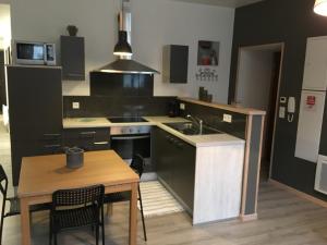 a kitchen with a table and a kitchen with a sink at Appartement impeccable en centre ville in Givet