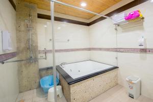 a bathroom with a shower and a bath tub at Kid Baby Homestay in Anping