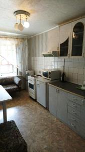 ノヴォシビルスクにあるЧелюскинцев 14/1の白い家電製品とソファ付きのキッチンが備わります。