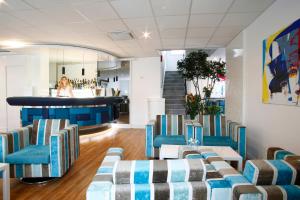 a waiting room with blue chairs and a bar at Hôtel Méditerranée in Calvi