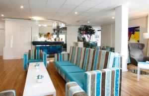 a restaurant with blue and white chairs and a bar at Hôtel Méditerranée in Calvi