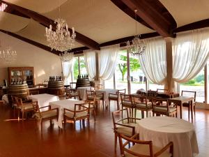 a dining room with tables and chairs and chandeliers at La Quercia Rossa in Moncalvo