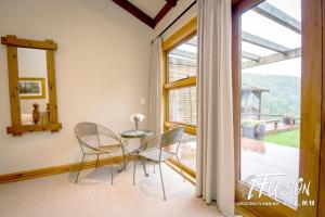 een eetkamer met een tafel en stoelen en een raam bij The Canyons B&B in Queenstown