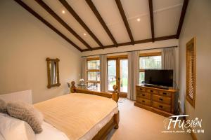 een slaapkamer met een bed en een flatscreen-tv bij The Canyons B&B in Queenstown