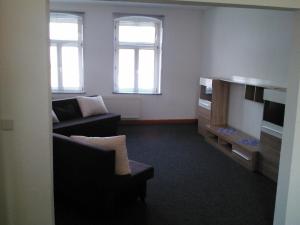 ein Wohnzimmer mit einem Sofa und einem TV in der Unterkunft Hostel Vorharz Aschersleben in Aschersleben