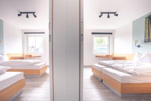 two beds in a room with two windows at Auszeit Das Hotel Himmelkron in Himmelkron