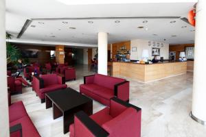 a hotel lobby with red chairs and a bar at Eurohotel Castellón in Castellón de la Plana