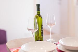 a bottle of wine and two glasses on a table at Apartments Stasic in Vrbnik