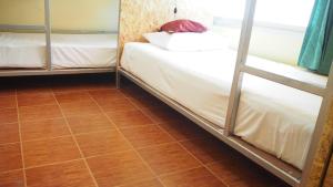 a room with two bunk beds and a wooden floor at Chaokoh Phi Phi Hostel in Phi Phi Don