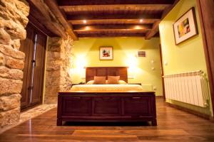 a bedroom with a bed and a stone wall at Hotel El Quintanal in Bode