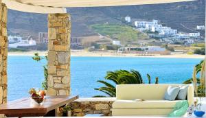 a couch on a patio with a view of the ocean at Mykonos Pantheon in Kalo Livadi