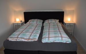 ein Bett mit zwei Nachttischen und zwei Lampen drauf in der Unterkunft Ferienwohnung im Winkel in Hanstedt
