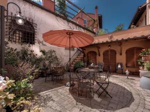 a patio area with a table, umbrella, and chairs at Hotel Palagi in Pietrasanta