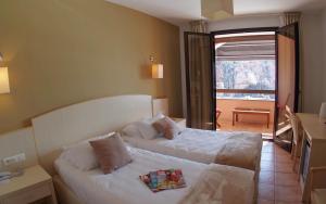 a hotel room with two beds and a balcony at Les Flots Bleus in Porto Ota +36 photos