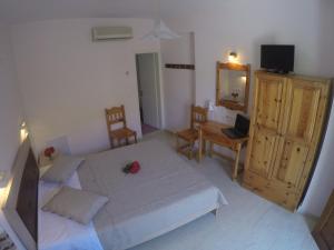 a bedroom with a bed and a desk with a laptop at Geroulis Stefanos Studios in Vasiliki