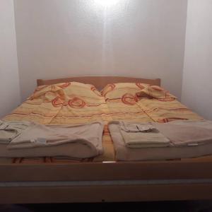 een ongeëvenaard bed met dekens erop bij Apartmani Sastavci in Tjentište