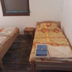 a small room with two beds and a table at Apartmani Sastavci in Tjentište