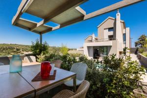 a table and chairs with a view of a house at Elea Villas - Aspro & Blanche in Almirida +30 photos