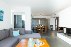 a living room with a couch and a table at Elea Villas - Aspro & Blanche in Almirida