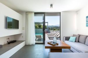 a living room with a couch and a table at Elea Villas - Aspro & Blanche in Almyrida