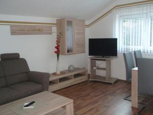 a living room with a couch and a flat screen tv at Ferienwohnung am Schloßberg in Arnstadt