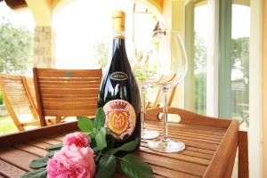 a bottle of wine sitting on a table with a glass at Villa Gardoncino in Manerba del Garda