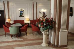 un restaurante con sillas rojas y una mesa con flores en Arm Premier Hotel, en Cherepovets