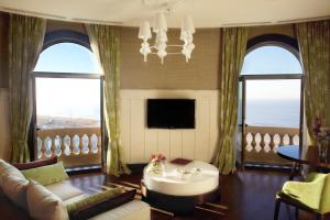 a living room with a couch and a chandelier at Sofitel Montevideo Casino Carrasco & Spa in Montevideo