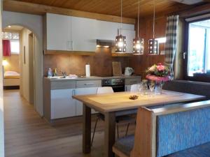 une cuisine avec une table en bois et une salle à manger dans l'établissement Appartement Anneke, à Niedernsill