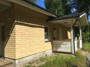 a brown brick house with a white fence at Foxy burrow in Verla