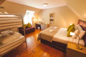 RaasayRaasay House Hotel的一间卧室，配有两张双层床和一张书桌