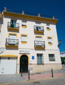 a large white building with windows and balconies at Apartamentos Manuel Martin in Nerja