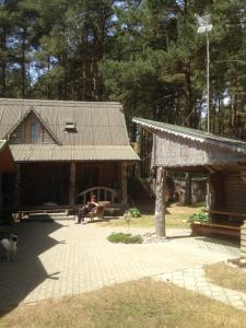 a person sitting on a bench in front of a house at Edmundas in Palanga