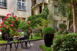 a table and chairs in front of a building with flowers at Le Patio Bastille in Paris