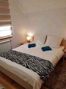 een bed met twee blauwe kussens erop bij Apartmani F&A in Zlatibor +10 foto's