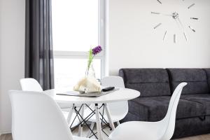 a white table with white chairs and a couch at Baltic Apartments Main Town Towers in Gdańsk