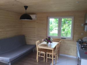 a room with a table and a couch and a table and chairs at Domek Letniskowy KAL in Węgorzewo